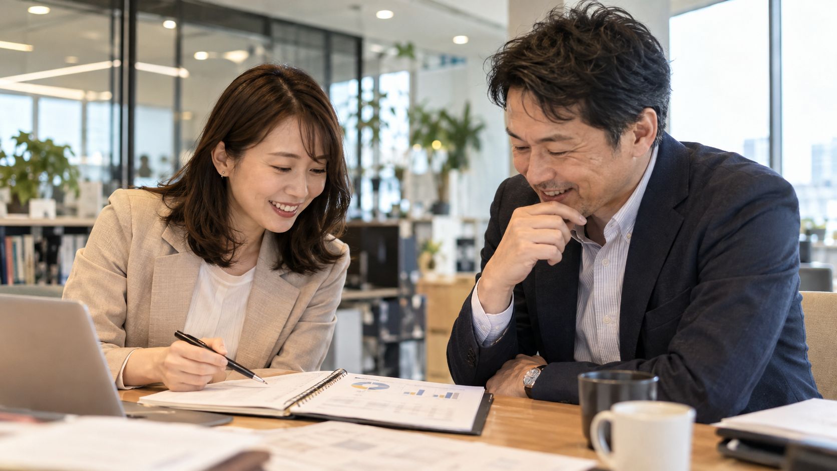 ノートパソコンで予算計画を一緒に確認する担当者と経営者